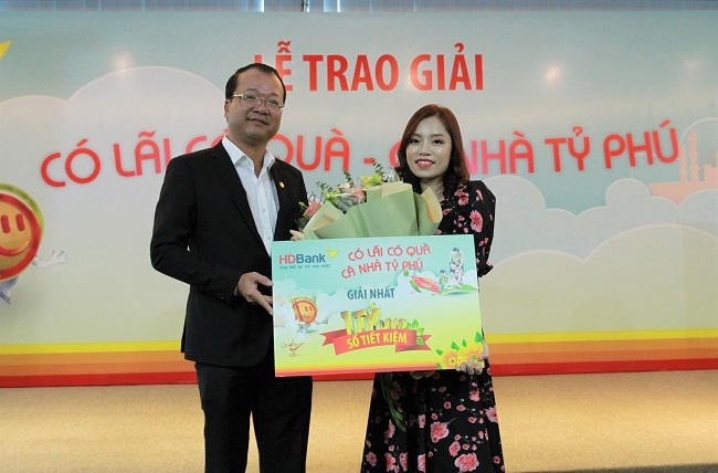 Ông Trần Quốc Anh – giám đốc khối KHCN HDBank chúc mừng khách hàng Đinh Thị Tuyết Nhung đã may mắn trúng giải Nhất trị giá tỷ đồng chương trình “Có lãi có quà – Cả nhà tỷ phú”